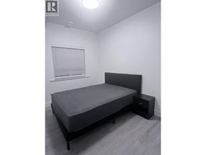 Vancouver apartment for rent - A bedroom with a bed, nightstand, and window with blinds.