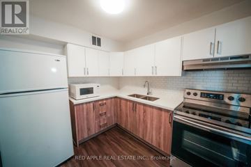 Toronto (Kingsview Village-The Westway) condo for rent - A kitchen with wooden cabinets and a stainless steel oven.