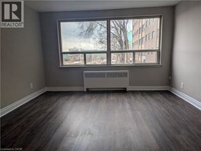 Hamilton condo for rent - A room with a large window and a radiator on the floor.