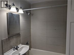Hamilton condo for rent - A bathroom with a white sink and a white bathtub.