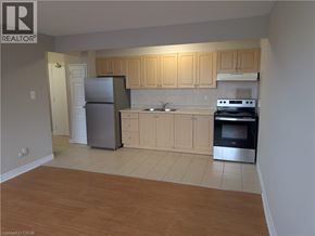 Hamilton condo for rent - A kitchen with wooden cabinets and a refrigerator.