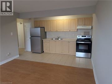 Hamilton condo for rent - A kitchen with wooden cabinets and a refrigerator.