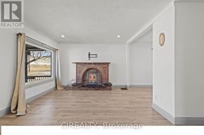 St. Catharines (E. Chester) apartment for rent - A room with a fireplace and a window with curtains.