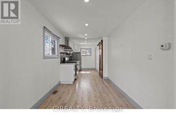 St. Catharines (E. Chester) apartment for rent - A well-lit, spacious kitchen with white appliances and wooden flooring.