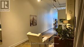 Toronto (Regent Park) condo for rent - A room with a chair, a table, and a plant.
