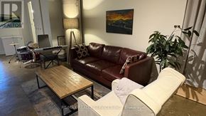 Toronto (Regent Park) condo for rent - A living room with a brown leather couch and a wooden coffee table.