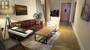 Toronto (Regent Park) condo for rent - A living room with a piano, a couch, a chair, and a rug.