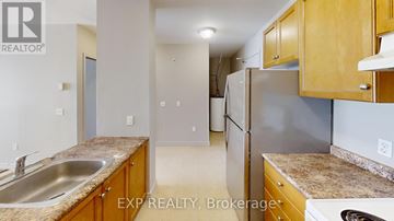 Orillia townhouse for rent - A kitchen with wooden cabinets and a stainless steel refrigerator.