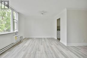 Barrie (Wellington) multi-family for rent - A spacious room with a window and a door leading to another room.