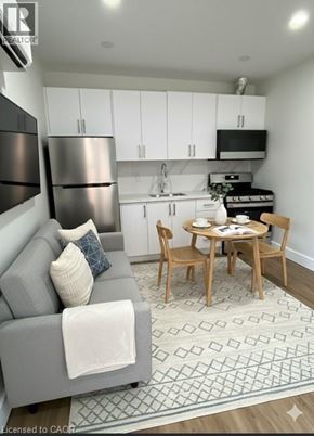 Hamilton apartment for rent - A modern kitchen with a grey couch and a dining table set for two.
