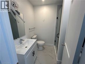 Hamilton apartment for rent - A bathroom with a toilet, sink, and mirror.