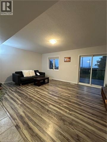 Kitchener townhouse for rent - A living room with a black couch and wooden flooring.