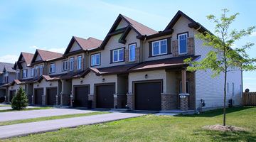 Arnprior apartment for rent - A row of houses with garages and driveways.