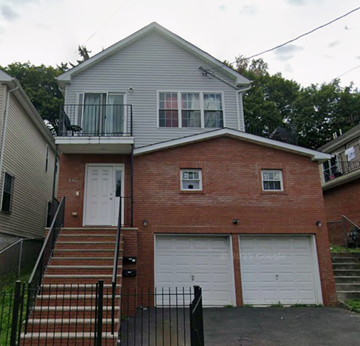 Irvington apartment for rent - A two-story house with a garage door and a balcony.