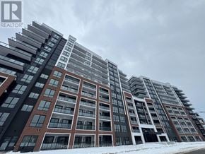 Clarington (Bowmanville) condo for rent - A large, modern residential building with multiple balconies and a mix of brick and glass facades.