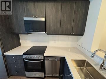 Clarington (Bowmanville) condo for rent - A modern kitchen with dark wood cabinets and stainless steel appliances.