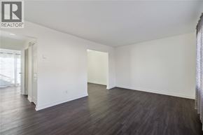 Sarnia townhouse for rent - A large empty room with wooden floors and white walls.