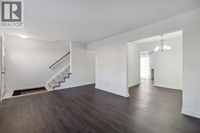 Sarnia townhouse for rent - A spacious room with a staircase and a door leading to another room.