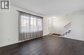 Sarnia townhouse for rent - A room with a staircase and a window with curtains.