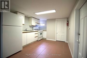 Toronto (Trinity-Bellwoods) apartment for rent - A kitchen with white appliances and brown tile flooring.