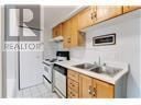 Hamilton (Corktown) condo for rent - A kitchen with wooden cabinets and a white fridge.