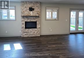 Whitchurch-Stouffville (Stouffville) apartment for rent - A spacious kitchen with white cabinets and a stone wall.