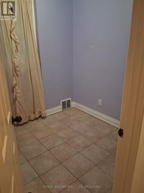 Niagara Falls (Downtown) apartment for rent - A room with a tile floor and a curtain.
