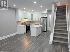Hamilton apartment for rent - A well-lit kitchen with a refrigerator, stove, and cabinets.