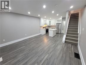 Hamilton apartment for rent - A spacious living room with a staircase leading to the upper floor.