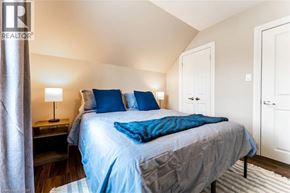 Stratford apartment for rent - A bedroom with a bed, two lamps, and a nightstand.