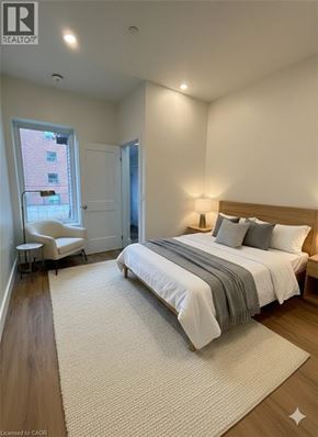 Hamilton apartment for rent - A bedroom with a large bed and a chair by the window.