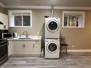 Surrey apartment for rent - A washer and dryer stacked on top of each other in a laundry room.
