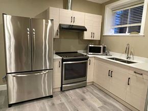 Surrey apartment for rent - A kitchen with a stainless steel refrigerator, oven, and microwave.