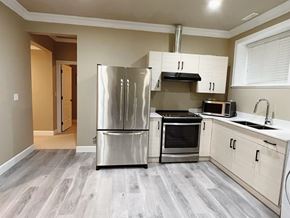 Surrey apartment for rent - A kitchen with a stainless steel refrigerator, microwave, and oven.