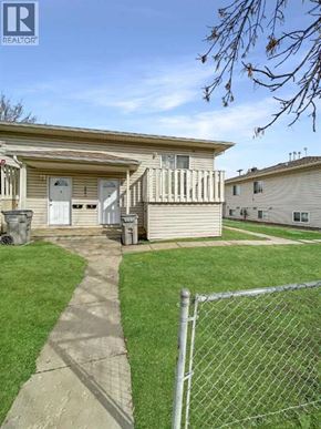 Grande Prairie apartment for rent - A house with a fence and a pathway leading to the front door.