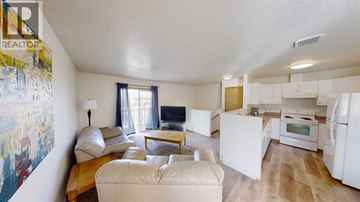 Grande Prairie apartment for rent - A living room with a couch, a table, and a painting on the wall.