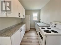 St. Catharines (Burleigh Hill) apartment for rent - A kitchen with white appliances and cabinets.
