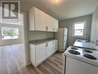 St. Catharines (Burleigh Hill) apartment for rent - A kitchen with white cabinets and a stove top oven.