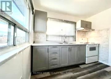Toronto (Corso Italia-Davenport) apartment for rent - A kitchen with a white oven and grey cabinets.
