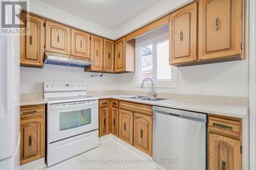 Mississauga (Streetsville) apartment for rent - A kitchen with wooden cabinets and white appliances.