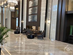 Ottawa apartment for rent - A modern lobby with a marble floor and dark wood furniture.