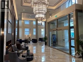 Ottawa apartment for rent - A large, well-lit lobby with a marble floor and a chandelier hanging from the ceiling.