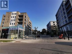 Waterloo condo for rent - A modern apartment building with a glass entrance and a clear blue sky.