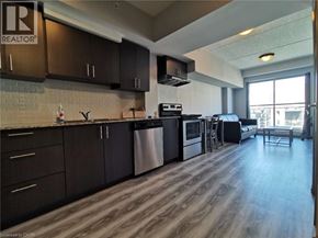 Waterloo condo for rent - A kitchen with dark wood cabinets and a stainless steel dishwasher.