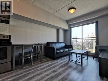 Waterloo condo for rent - A living room with a black couch and a coffee table.