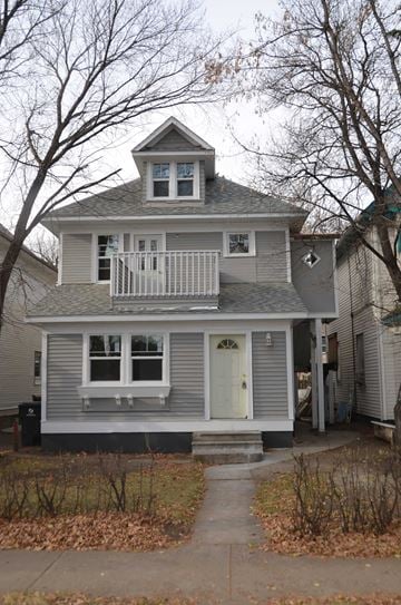 Saskatoon apartment for rent - A grey house with a white door and a small porch.