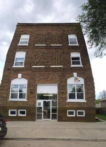 Prince Albert apartment for rent - A brick building with a white door and windows.