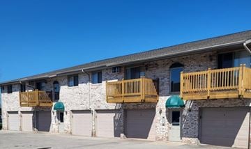 Green Bay apartment for rent - A building with a stone facade and wooden balconies.