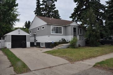 Saskatoon apartment for rent - A house with a garage and a driveway.
