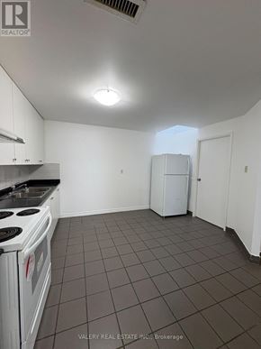 Toronto (South Riverdale) apartment for rent - A kitchen with white cabinets and a white stove top oven.